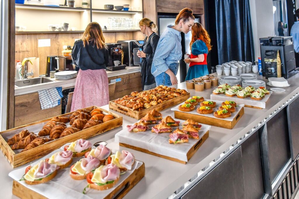 Fotka miestnosti pripravená na Business Breakfast Bratislava so stolmi, materiálmi a pohostením.